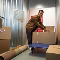 A man moving boxes into a self storage unit