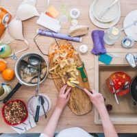 Someone making food on a cluttered kitchen counter