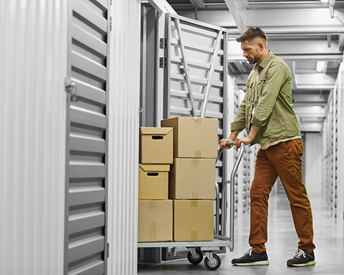 Man moving boxes into a storage unit