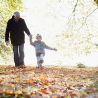 A grandfather walking with his grandchild